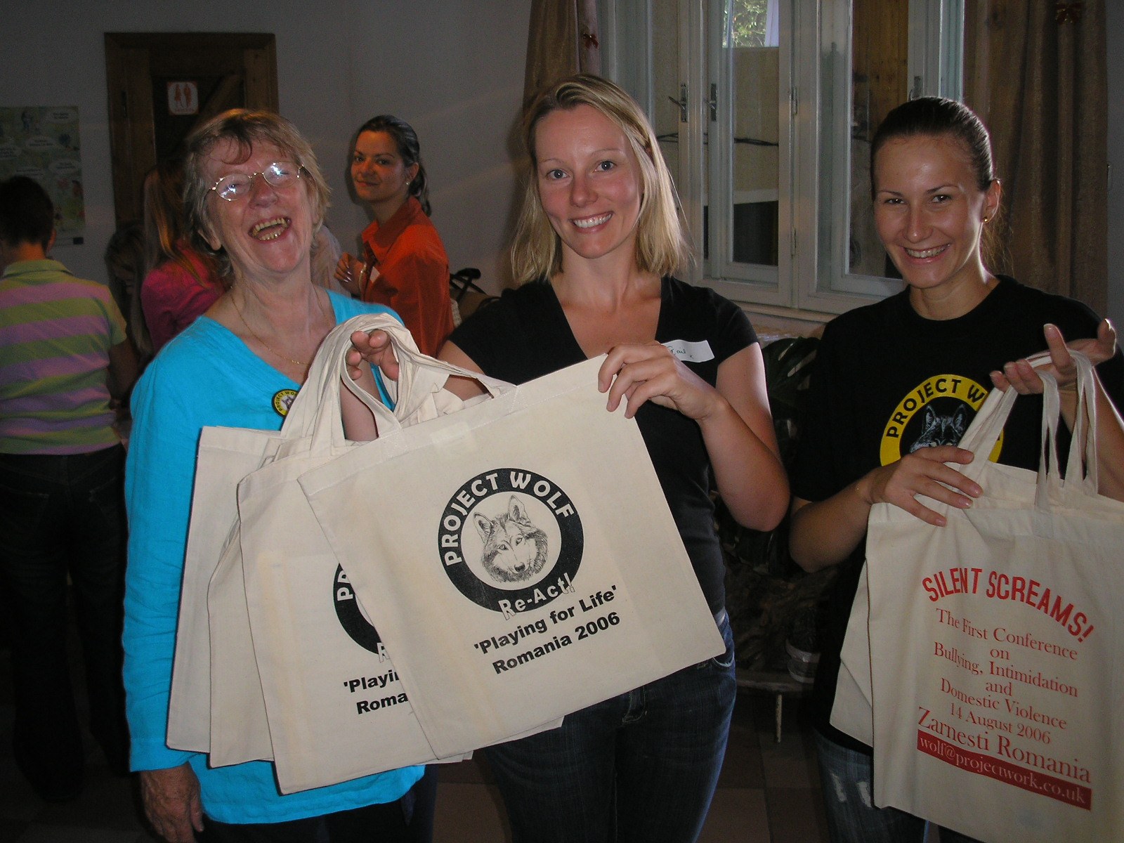 Sue with people holding Project Wolf bags during work in Romania
