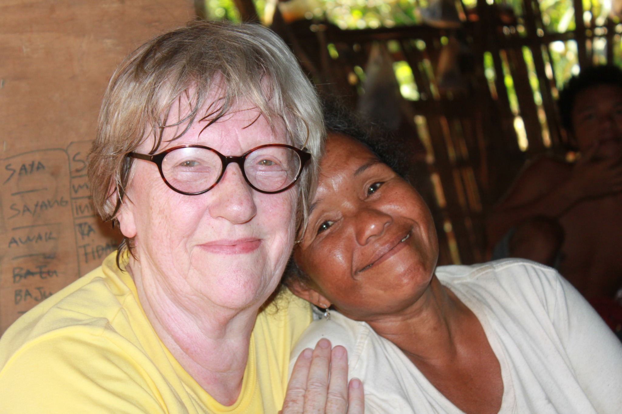 Sue sitting closely with a Temiar family member
