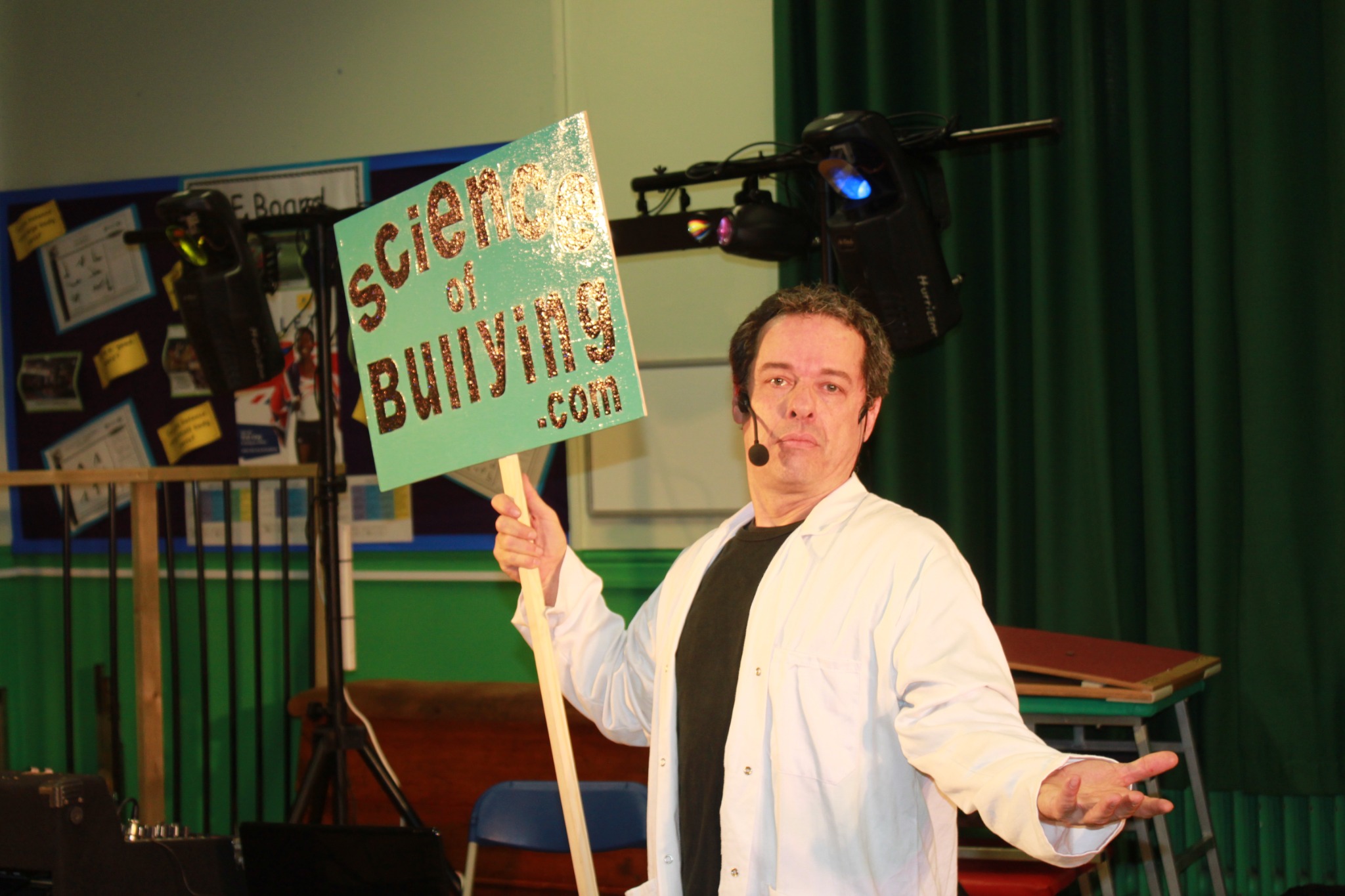 Andy presenting while holding a Science of Bullying sign