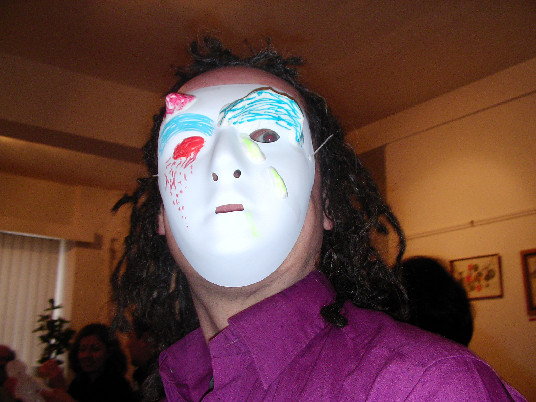 Person wearing a painted white theatre mask