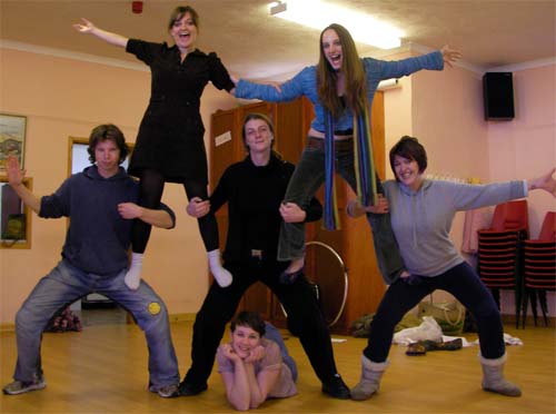 A theatre ensemble posing playfully together